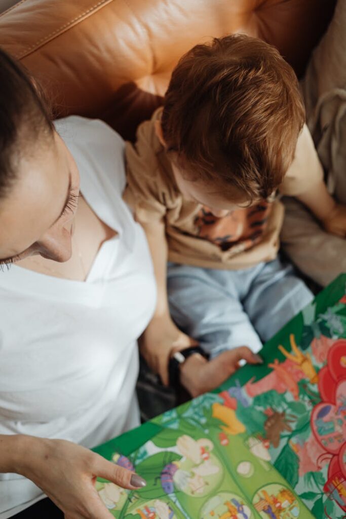 A mother and child reading a colorful book together, enjoying quality time indoors.